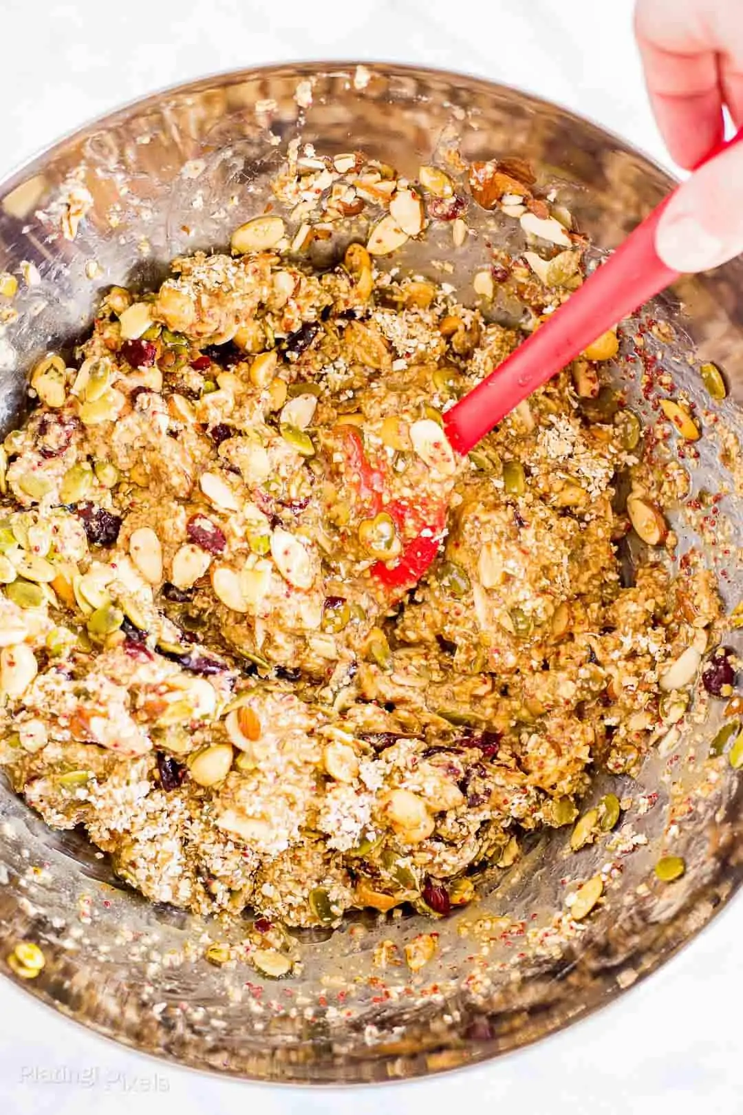 Process shot of mixing together ingredients in a bowl to make Cranberry Almond Granola Bars