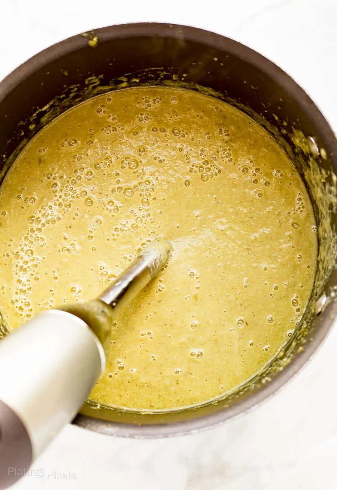 Process shot of blending leek soup with an immersion blender