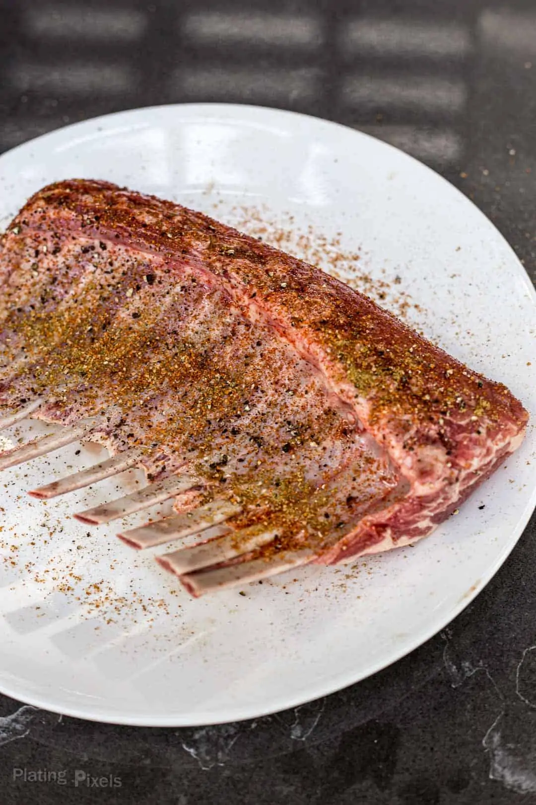 A seasoned rack of lamb resting at room temp