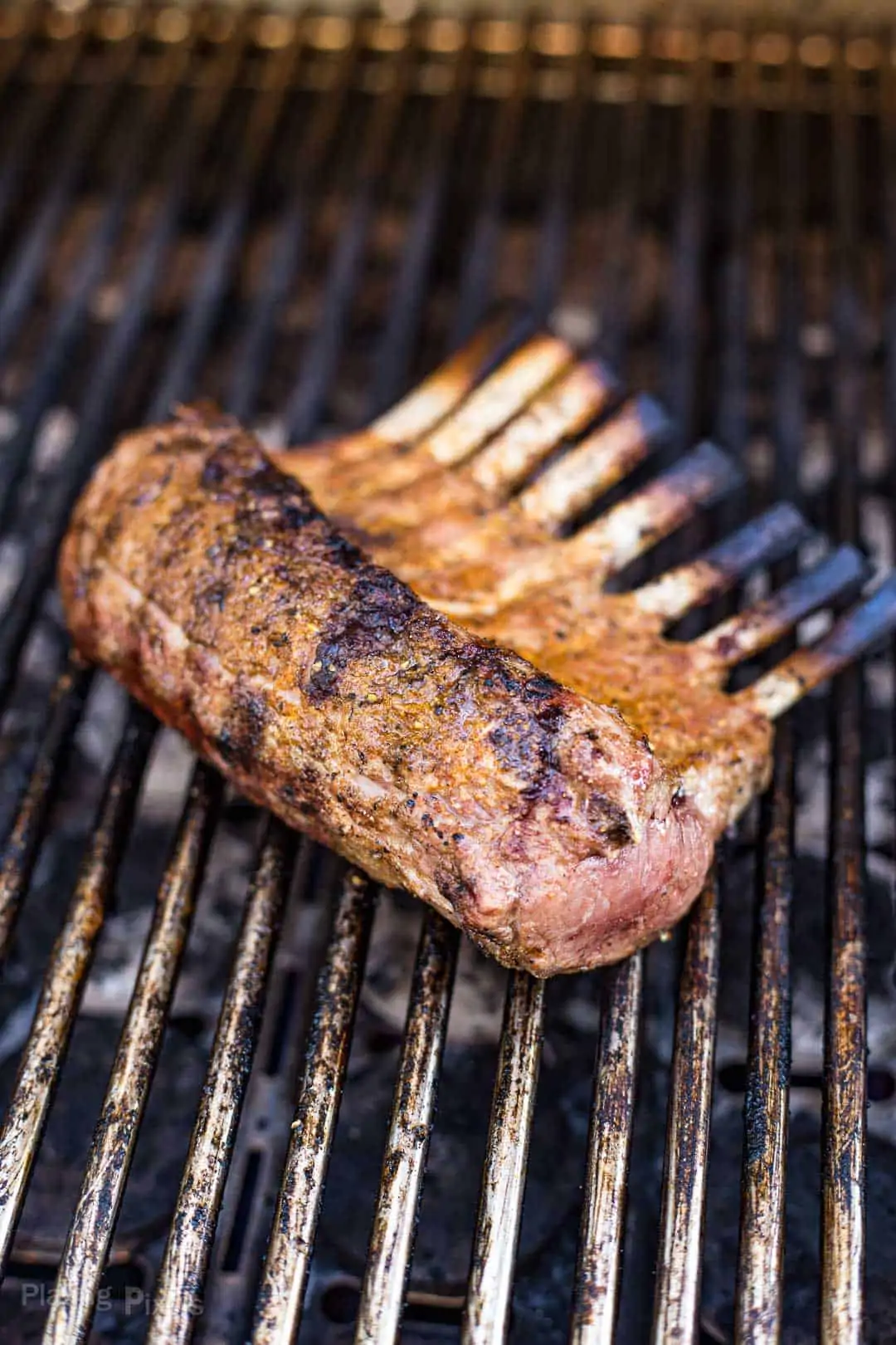 A rack of lamb cooking on a gas grill
