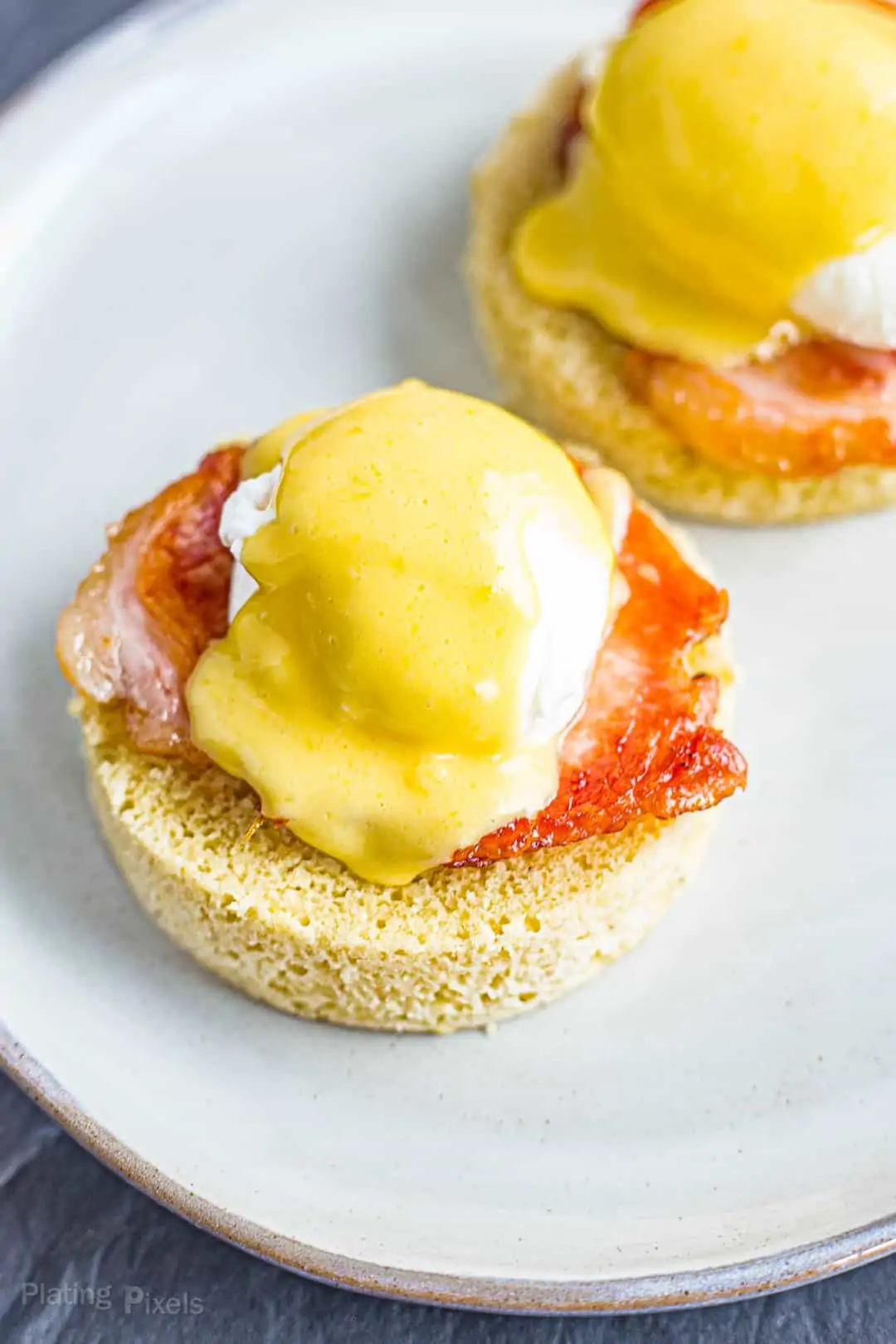Hollandaise Sauce spread over Keto Eggs Benedict on a plate
