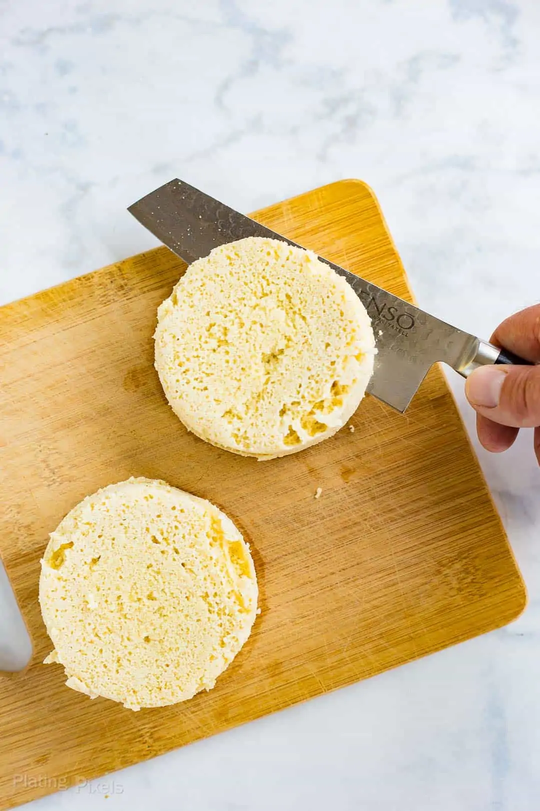 Cutting a cooked Keto English Muffin in half with a knife