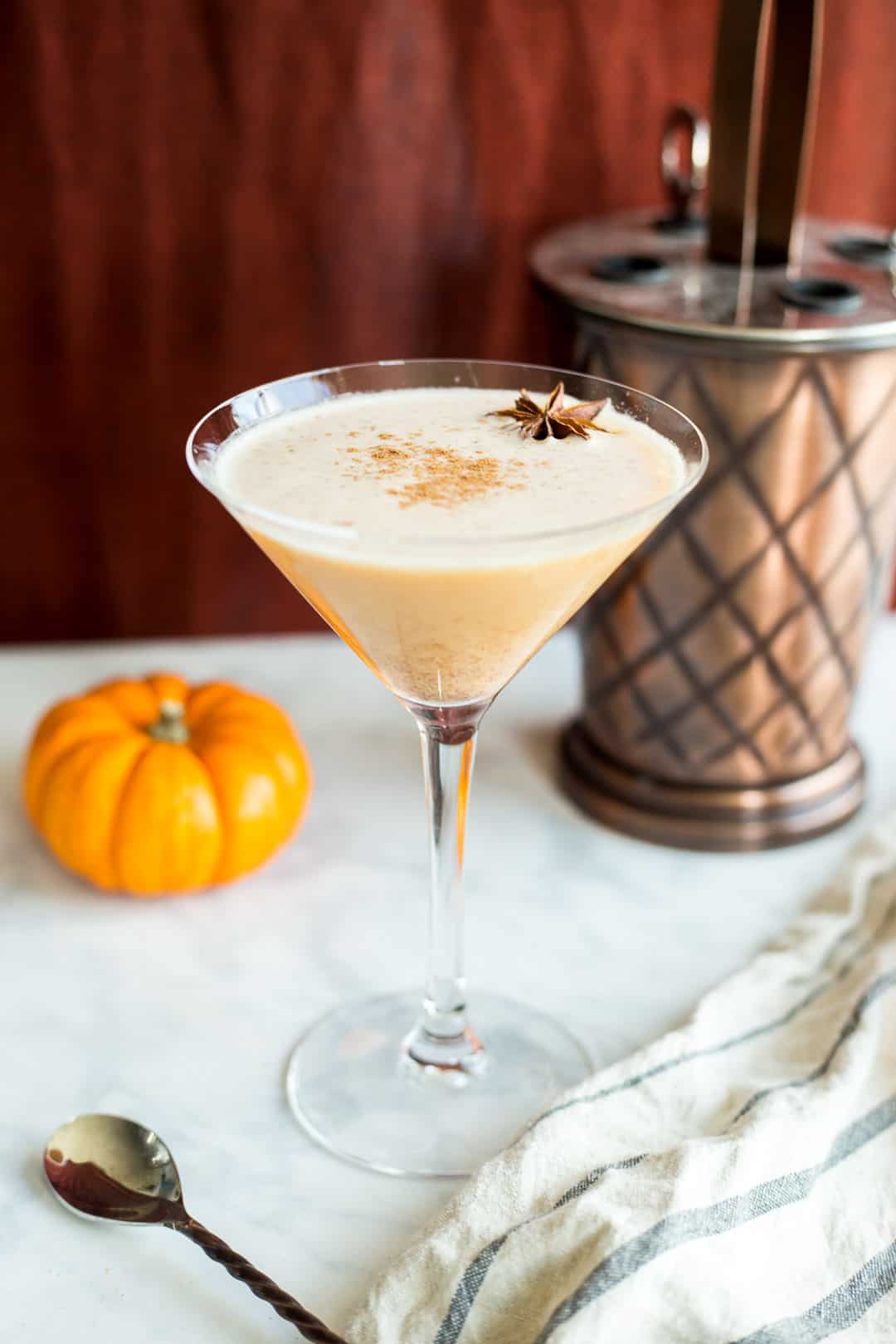 Pumpkin Pie Martini in a glass next to a bar tools set