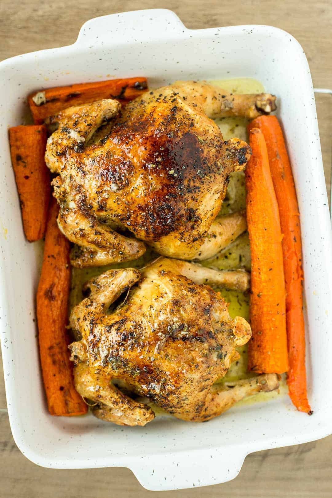 Roasted Cornish Hens in a baking dish served with carrots