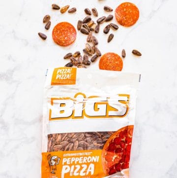 Bigs Pepperoni Pizza Sunflower Seeds in bag next to pepperoni slices