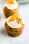 Close up of a Carrot Cake Cupcake topped with cream cheese frosting and marzipan carrot