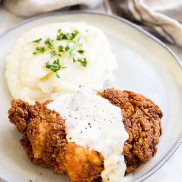 Prepared Chicken Fried Chicken on a plate served with mashed potatoes and country gravy
