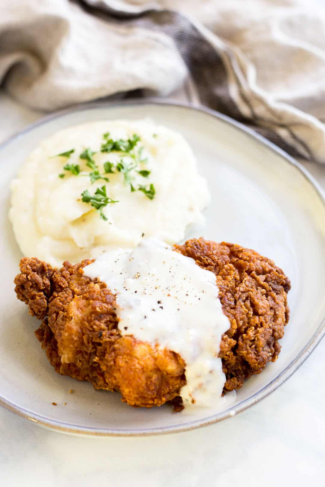 Prepared Chicken Fried Chicken on a plate served with mashed potatoes and country gravy