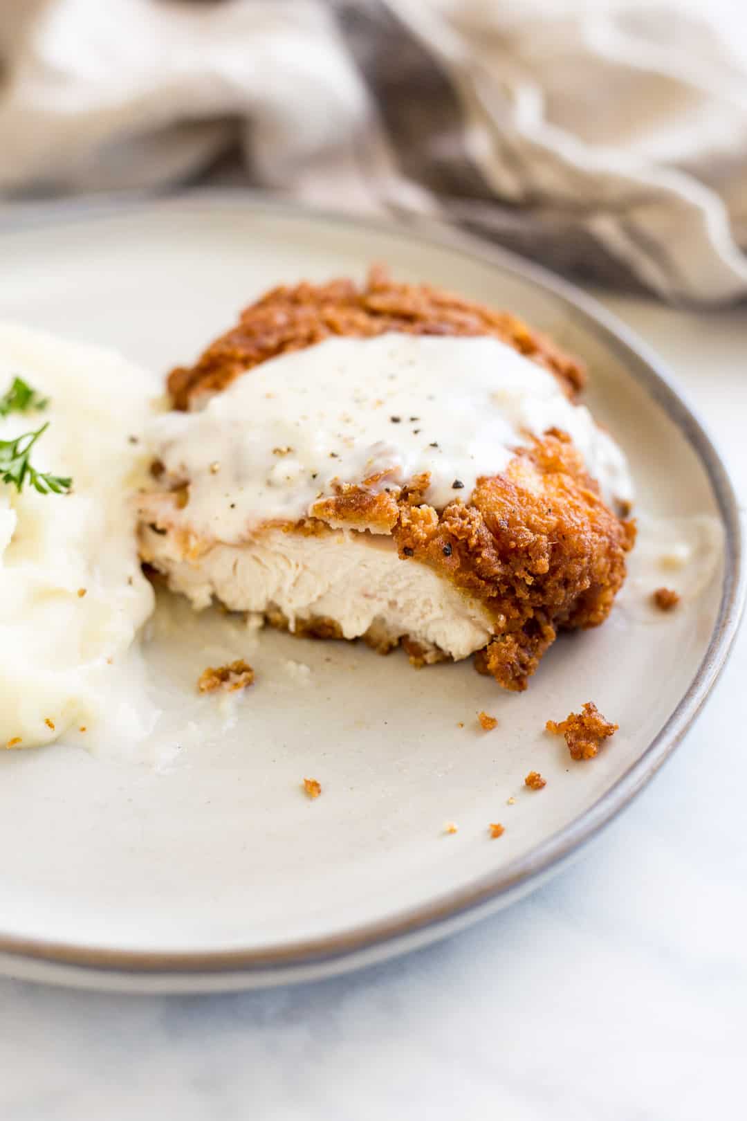 Chicken Fried Chicken on a plate with slice cut out of it