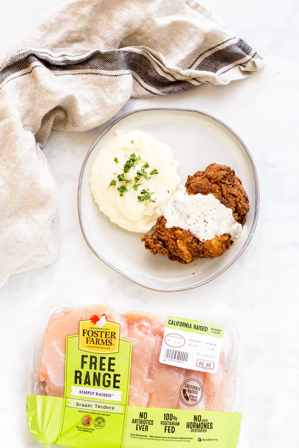 A plate of Chicken Fried Chicken next to package of Foster Farms chicken breasts