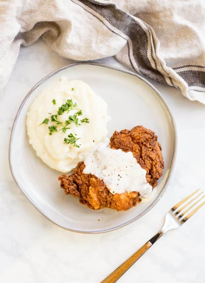 Overhead shot of Chicken Fried Chicken smothered with country gravy