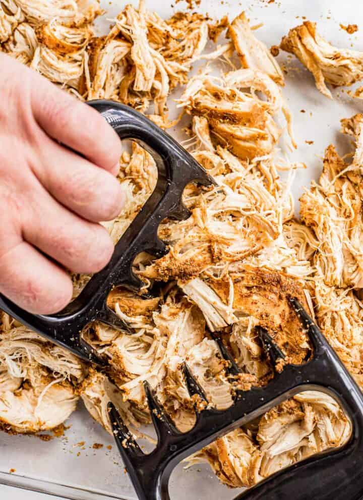 Using meat claws to shred slow cooked chicken