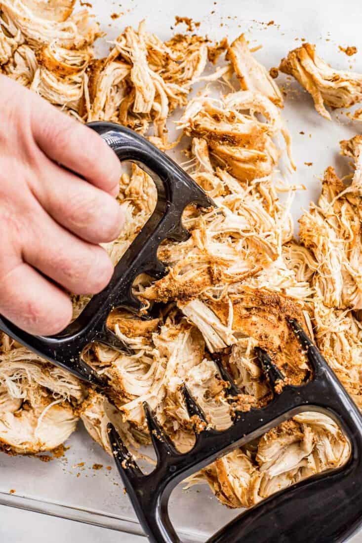Using meat claws to shred slow cooked chicken