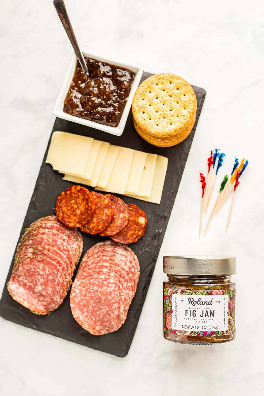 Jar of Roland Foods Fig Jam next to a charcuterie board