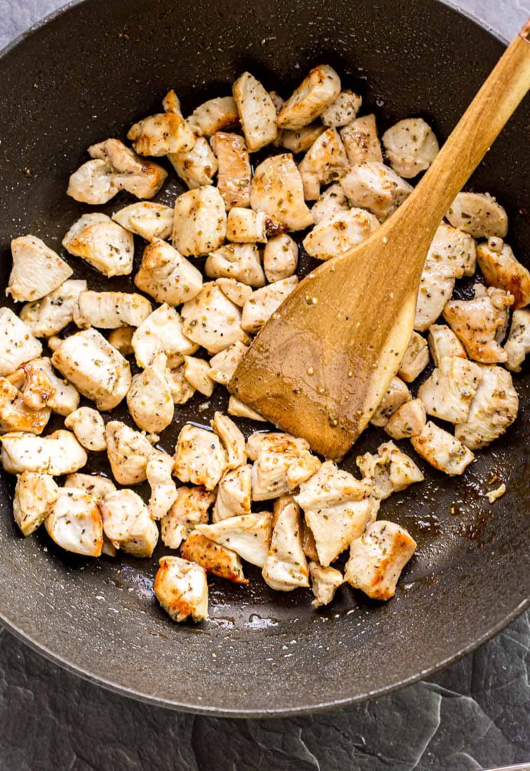 Searing chicken breast pieces in a pan