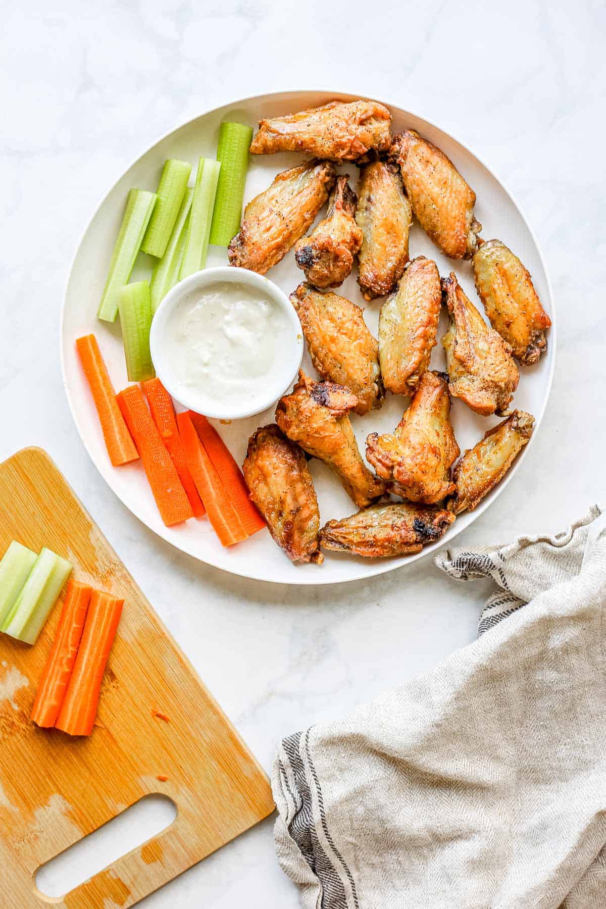 Overhead photo of Air Fried Chicken Wings on a plate with dipping sauce, carrots and celery