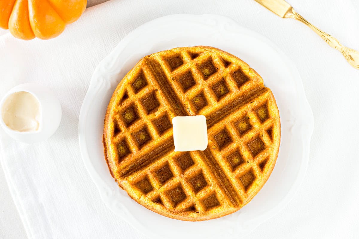 Horizontal photos of a Pumpkin Waffle on a plate with butter