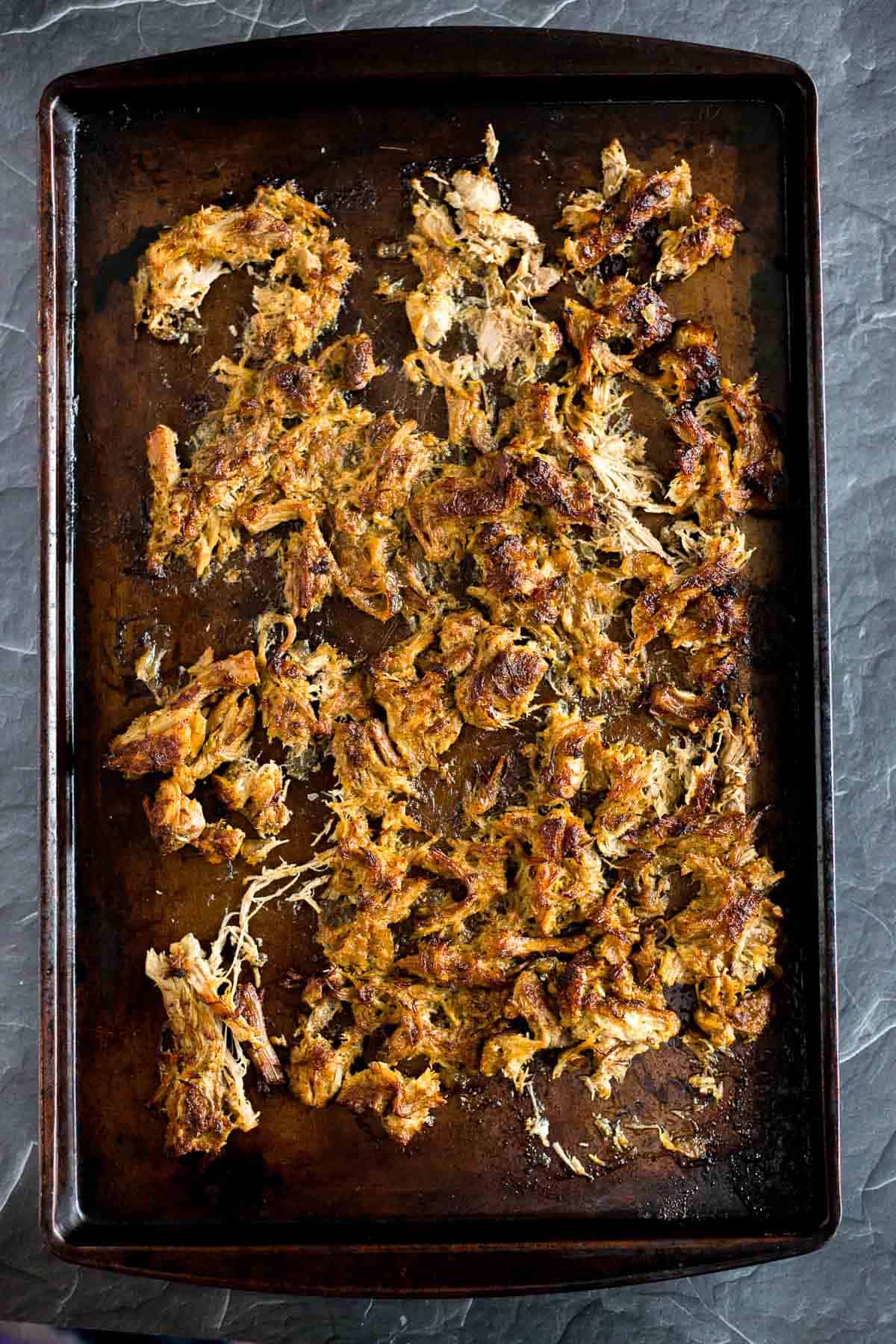 Browned crispy pork carnitas on a baking sheet